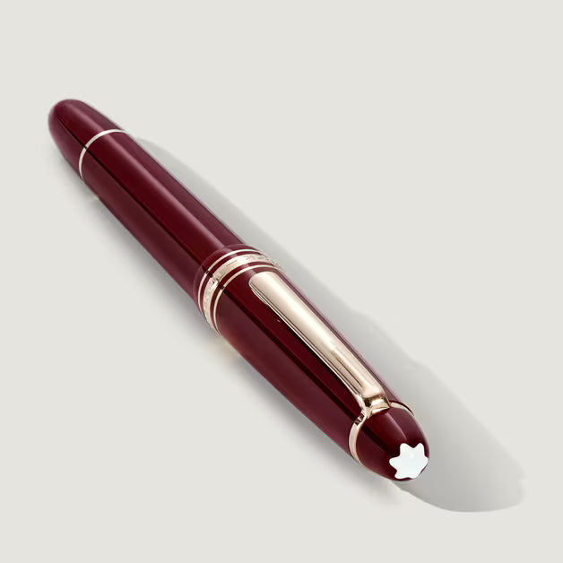 Maroon pen with gold accents on a light gray background