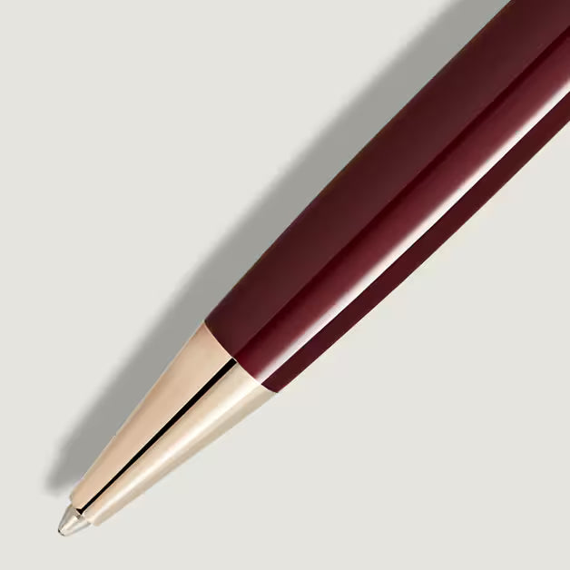 Maroon pen with gold cap on a light gray background