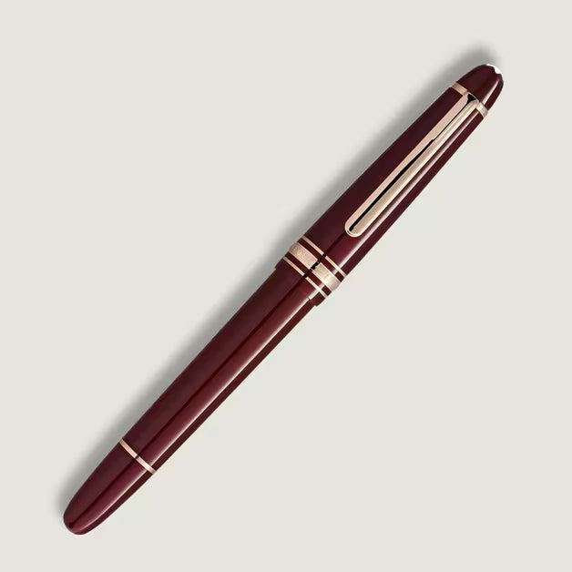 Maroon pen with gold accents on a light gray background