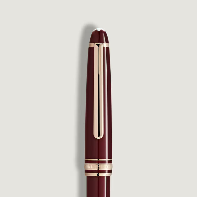 Maroon pen with gold accents on a light gray background