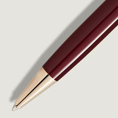 Maroon pen with gold cap on a light gray background