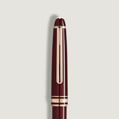 Maroon pen with gold accents on a light gray background